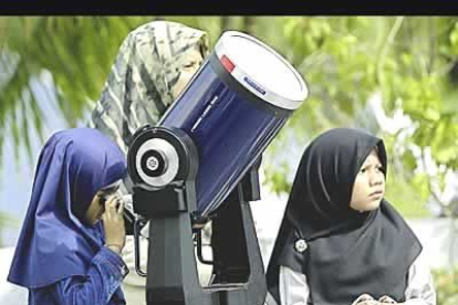 Dos niñas malasias observan el fenómeno astronómico desde el observatorio de Kuala Lumpur.