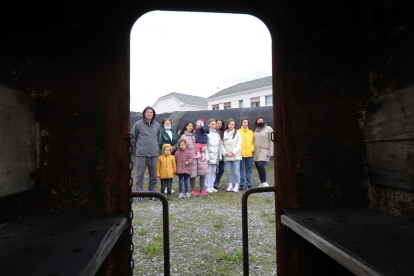 Foto de familia de los ucranios que han encontrado refugio en Fabero, vista desde el interior de los viejos vagones mineros que se conservan en el Pozo Julia. ANA F. BARREDO