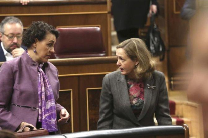 La ministra de Trabajo, Magdalena Valerio, conversa con la titular de Economía, Nadia Calviño, en el Congreso de los Diputados.