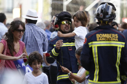 Un bombero con un niño en brazos durante la marcha