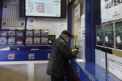 Un hombre sella un boleto en una administración de lotería. J. F. S.