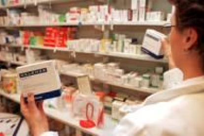 Una farmacéutica muestra uno de los medicamentos de su establecimiento