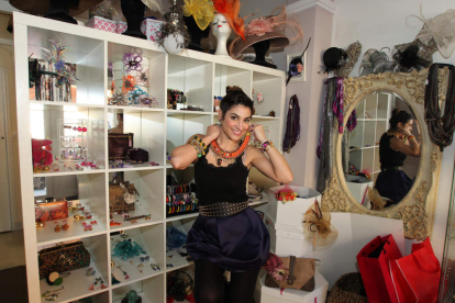 Sandra Palomar posa en su tienda taller junto a algunas de sus creaciones como collares, pendientes o tocados que hace personalizados.