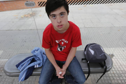 Rubén Calleja esperando, en 2014, en la parada del autobús para dirigirse a al centro de Amidown, en el colegio público Cervantes. JESÚS F. SALVADORES
