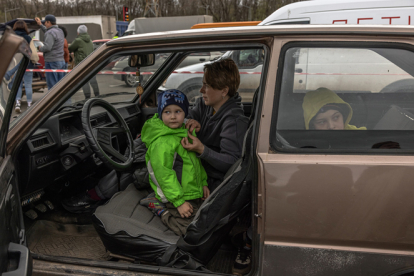 Una mujer con niños, tras huir de la zona ocupada por Rusia en el sur de Ucrania, se sienta en un coche después de llegar al punto de evacuación en Zaporizhzhia. ROMAN PILIPEY / EFE