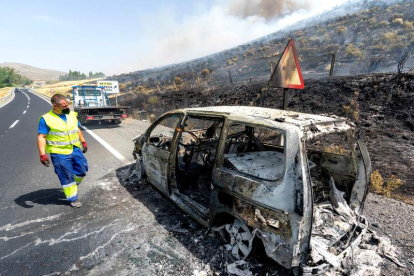 El coche que se incendió provocando un fuego forestal y un helicóptero sofocando las llamas al borde de la N-502. RAÚL SANCHIDRIÁN