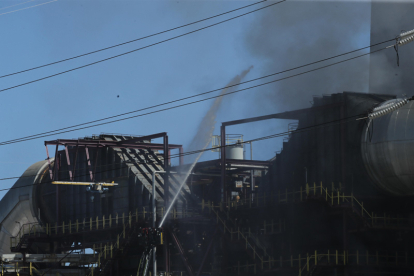 Bomberos trabajando en la extinción ayudados de una autoescala. L. DE LA MATA