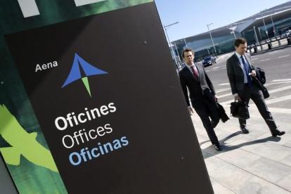 Dos hombres pasean cerca de las oficinas de AENA en el aeropuerto de Barcelona.
