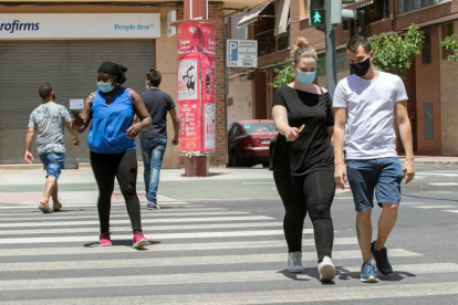 Varias personas con mascarilla cruzan un paso de peatones este lunes en la Avenida de Europa de Lorca. MARCIAL GUILLÉN