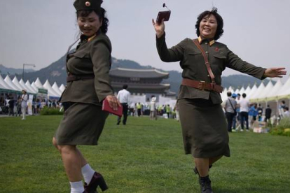 Desertoras de Corea del Norte bailan con uniformes militares de su país de origen en una exposición por la unificación de las dos Coreas, en Seúl, este viernes.