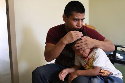 Un inmigrante centroamericano abraza a su hijo después de que lograran reunirse en El Paso, Texas.