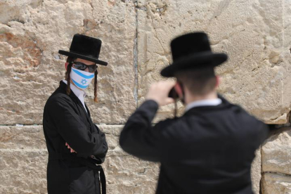 Un judío ortodoxo con mascarilla posa para una fotografía junto al Muro de las Lamentaciones. EFE