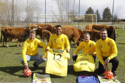 Miembros del equipo de fútbol del Quintana de Raneros CF, organizadores del evento, junto a las vacas que repartirán suerte. M. P.