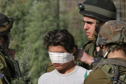 Un soldado israelí venda los ojos de un detenido palestino cerca de Nablus, en Cisjordania.