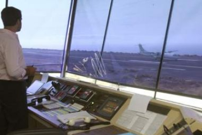 Un operario observa desde la torre de control el aterrizaje de un avión.