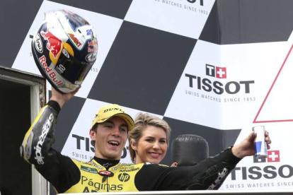 Maverick Viñales levantando su casco para celebrar la victoria en Moto 2 en el Gran Premio australiano de Phillip Island.
