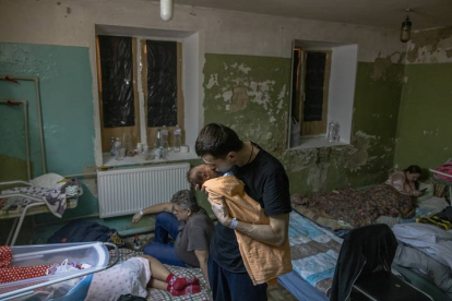 Un padre sostiene en brazos a su hijo recién nacido durante la alerta en Ucrania. ROMAN PILIPEY