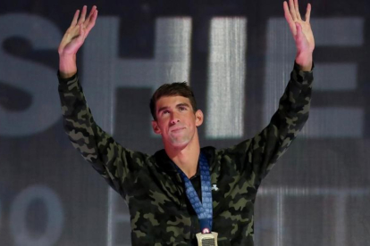 Phelps saluda desde el podio tras conquistar el triunfo en los 100 mariposa