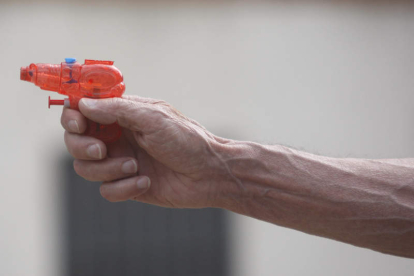 Un abuelo juega con la pistola de agua de su nieto. JESÚS F. SALVADORES
