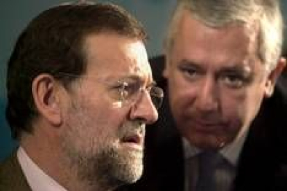 Mariano Rajoy conversa con Javier Arenas durante el acto preelectoral que celebró ayer en Sevilla