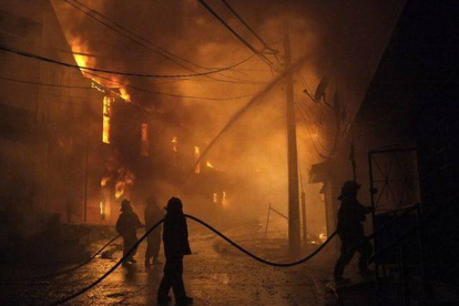 Bomberos intentan controlar el incendio en uno de los cerros de la ciudad de Valparaíso (Chile).