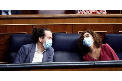 Pablo Iglesias habla con María Jesús Montero en el Congreso, durante la moción de censura de Vox. MARISCAL