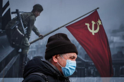 Un hombre pasa ayer por delante de un mural en Moscú. YURI KOCHETKOV