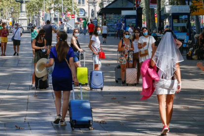 Varias turistas caminan por las Ramblas de Barcelona , hoy domingo. QUIQUE GARCÍA