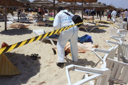 Un policía examina a dos víctimas del ataque terrorista en uno de los hoteles de Susa, en Túnez, el pasado 26 de junio.