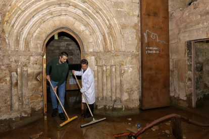 Dos hombres achican agua en el monasterio de Santa María la Real de Aguilar de Campóo. BRÁGIMO