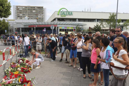 Los ciudadanos depositan flores junto al centro comercial. KARL-JOSEF HILDENBRAND