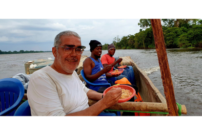 Manuel Félix en una de las comidas en canoa por el río Congo con un tripulante y un mecánico.