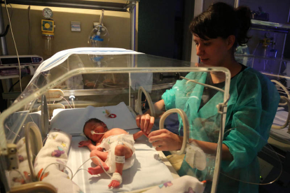 Alexandra da masajes a su hija en la UCI de neonatos del Hospital de León