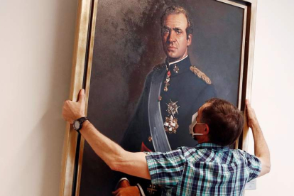 Un empleado del Ayuntamiento de Pamplona retira en junio el retrato de Juan Carlos I. JESÚS DIGES