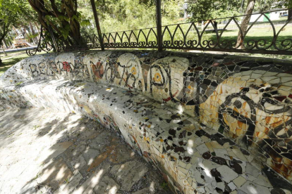 Bancos del parque vandalizados con grafiti.