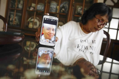 La hermana del piloto del avión de Malaysia desaparecido muestra una fotografía de su hermano.