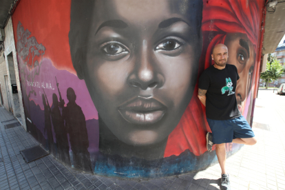 Asier Vera junto a otro mural antirracista también en la calle San Frutuoso.  L. DE LA MATA