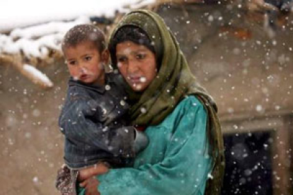 Una refugiada afgana sujeta en brazos a su bebé.