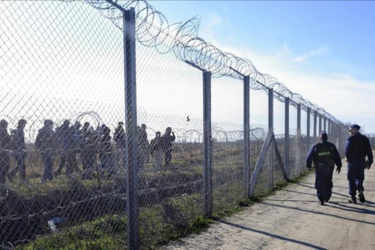 Un grupo de refugiados pasa por la valla que separa a Hungría de Serbia.