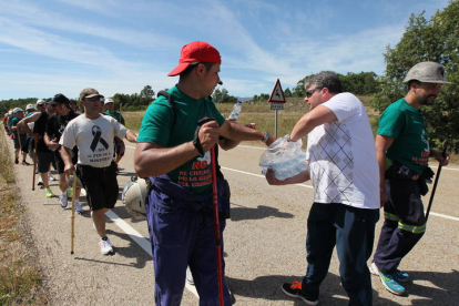 Hombre dando agua a los mineros durante la III Marcha Minera. NOBERTO.