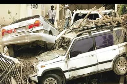 El paso del huracán por Jamaica ha dejado numerosos daños materiales. Su fuerza queda demostrada con este amasijo de árboles, coches y barro.