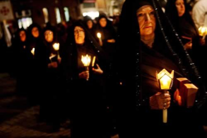 La luz de los faroles rompe la oscuridad de la noche del Lunes Santo.