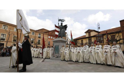 Los miembros de la Imperial Cofradía del Milagroso Pendón de San Isidoro bajo la escultura de Alfonso IX.