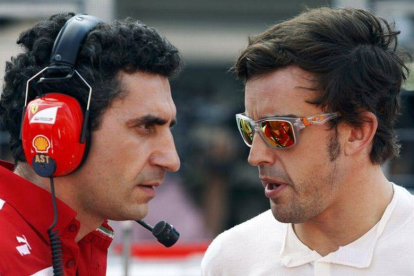 Fernando Alonso habla con un ingeniero tras el Gran Premio de Japón, donde ha tenido que abandonar.