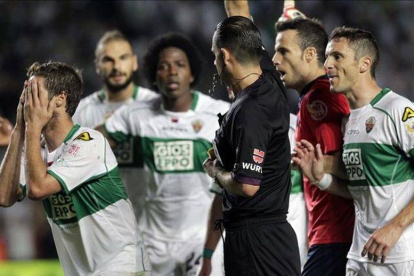 Muñiz Fernández, rodeado de jugadores del Elche tras pitar el penalti a Pepe.