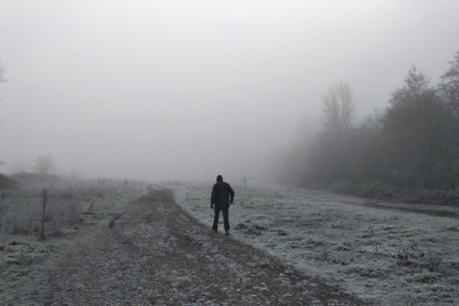 Un hombre camina entre la helada y la niebla en el Bierzo. CÉSAR SÁNCHEZ
