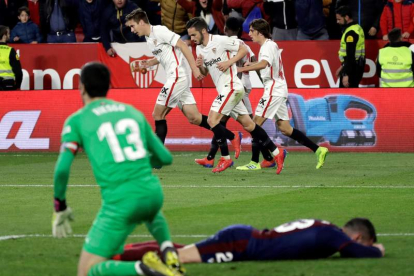 Los futbolistas del Sevilla celebran el empate ante la desolación de los jugadores del Eibar. JULIO MUÑOZ