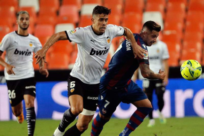 El brasileño Gabriel Paulista (i), del Valencia CF, lucha con Sergio León, del Levante. JUAN CARLOS CARDENAS