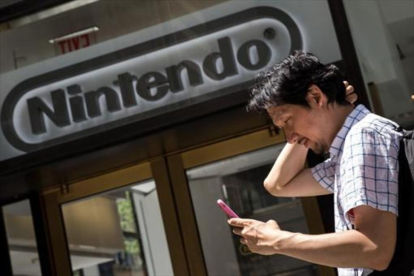 Un hombre juega al Pokémon Go con su móvil frente a la sede de Nintendo en Nueva York, el lunes.
