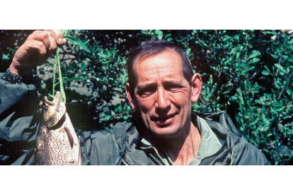El escritor vallisoletano Miguel Delibes, gran aficionado a la pesca, sostiene una trucha en la mano. EFE